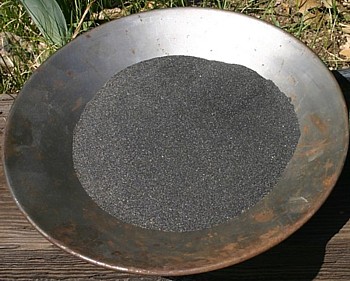 Large pan full of black sand